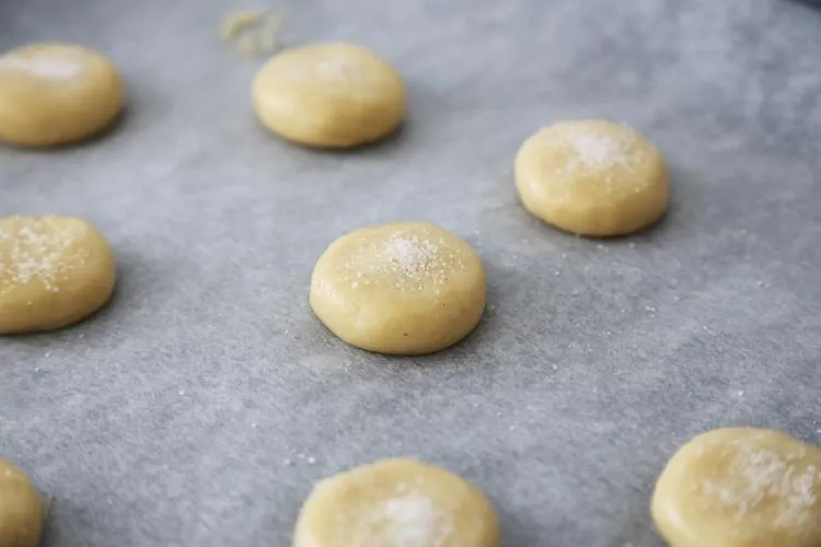 Porciones de masa de galletas de nata sobre papel de horno, antes de hornear
