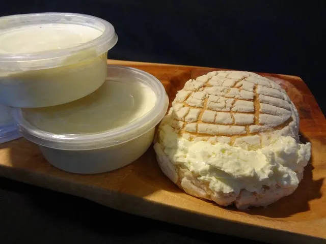 Tarrinas de nata casera junto a un pan con nata untada